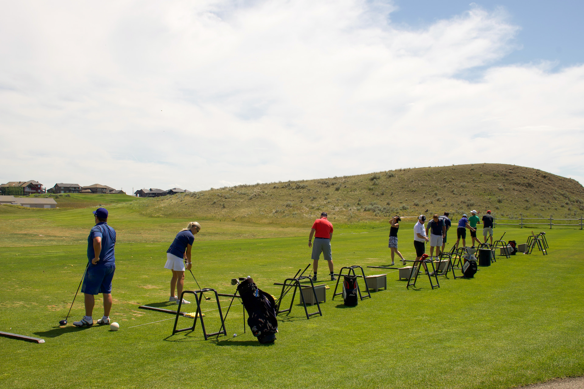 multiple golfers practicing on the grass driving range at desert blume golf course